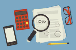 illustration of desktop with a magnifying glass over jobs section in newspaper