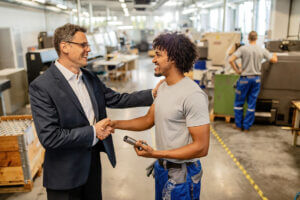 A man shaking hands with his boss after getting a raise.