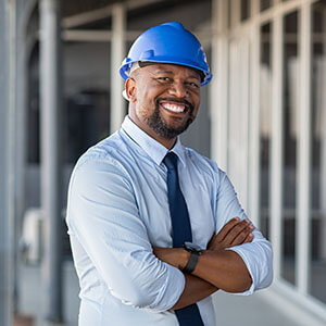 Man smiling in a hard hat representing the engineering industry.