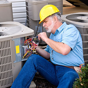 A man fixing an air conditioner representing the repair industry.