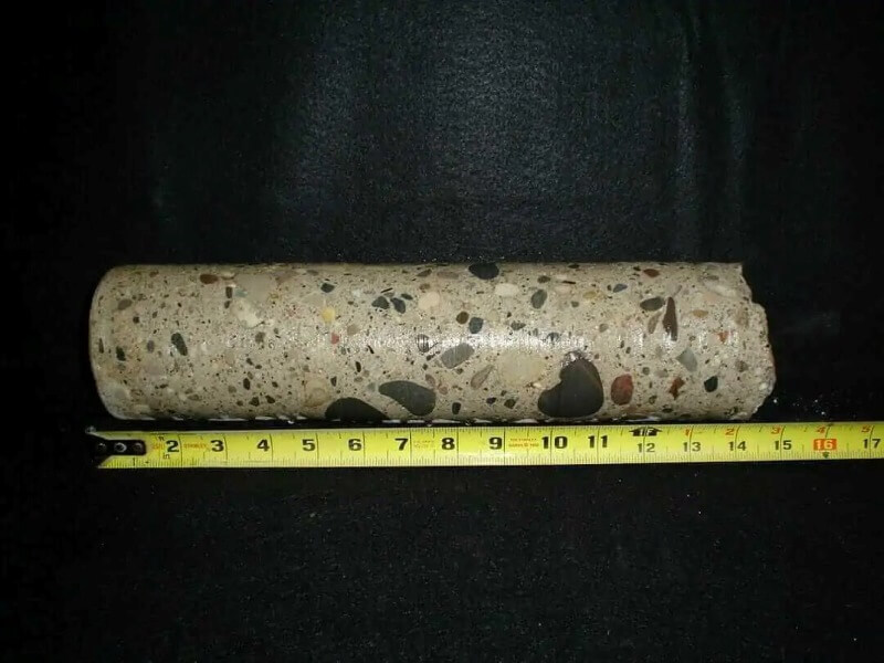 14” by 4” diameter rock core sample showing different sediments and rock property substances