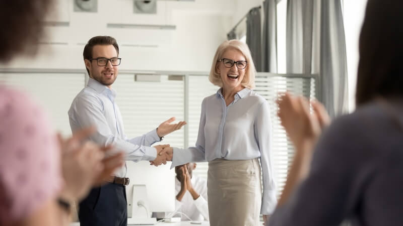 male boss shaking hands with woman admin on administrative professionals day