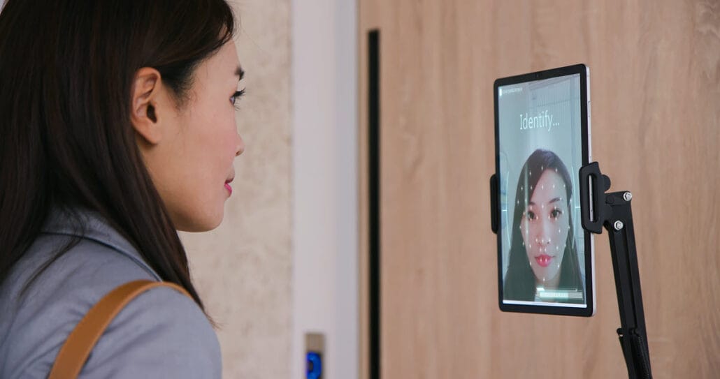 Facial recognition tech innovation with individual and laptop screen, used for enhancing workplace safety
