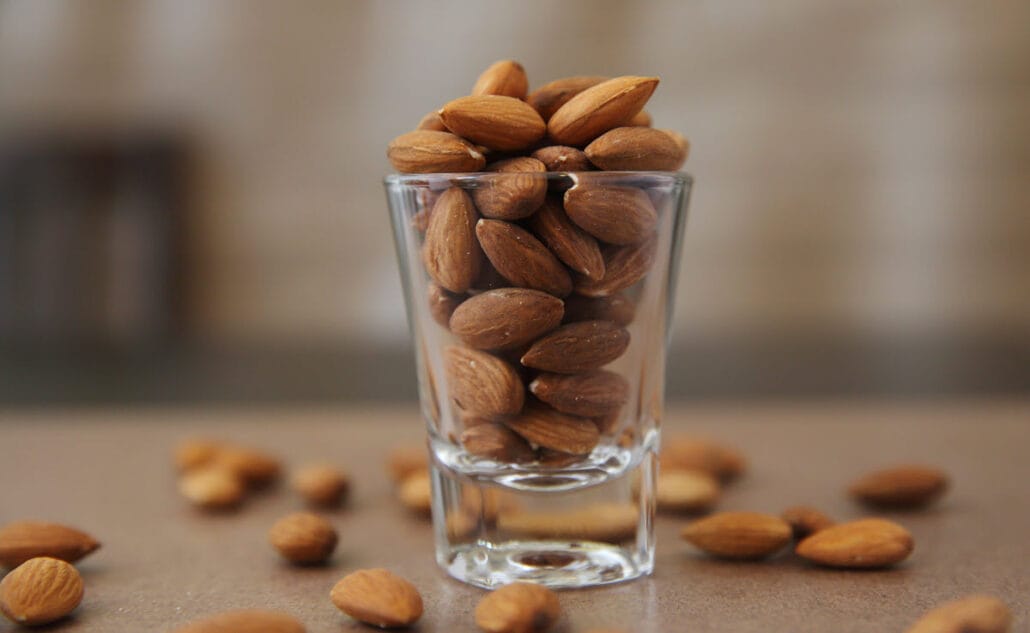 A shot glass filled with almonds