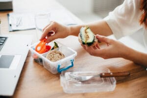 Woman eating healthy snacks at her desk
