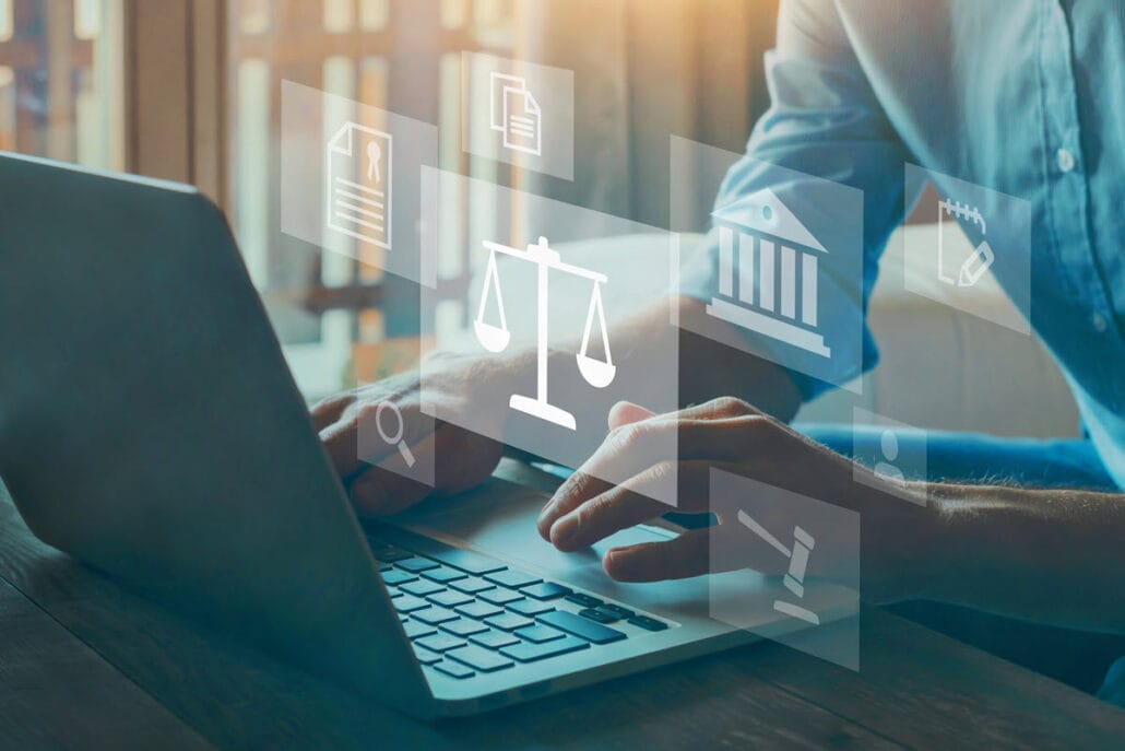 A labor and employee relations manager typing on a computer with floating images of judge scales and certificates