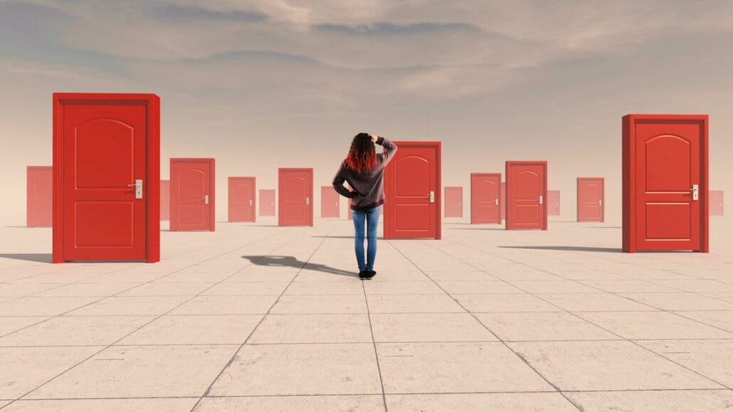 An image showing a woman standing in front of many doors depicting the search for a new path through self discovery