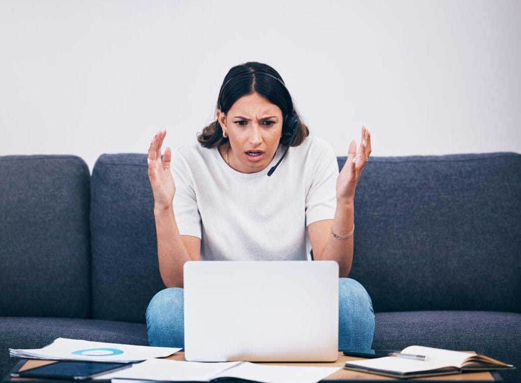 An unhappy woman working at home representing remote jobs to avoid.