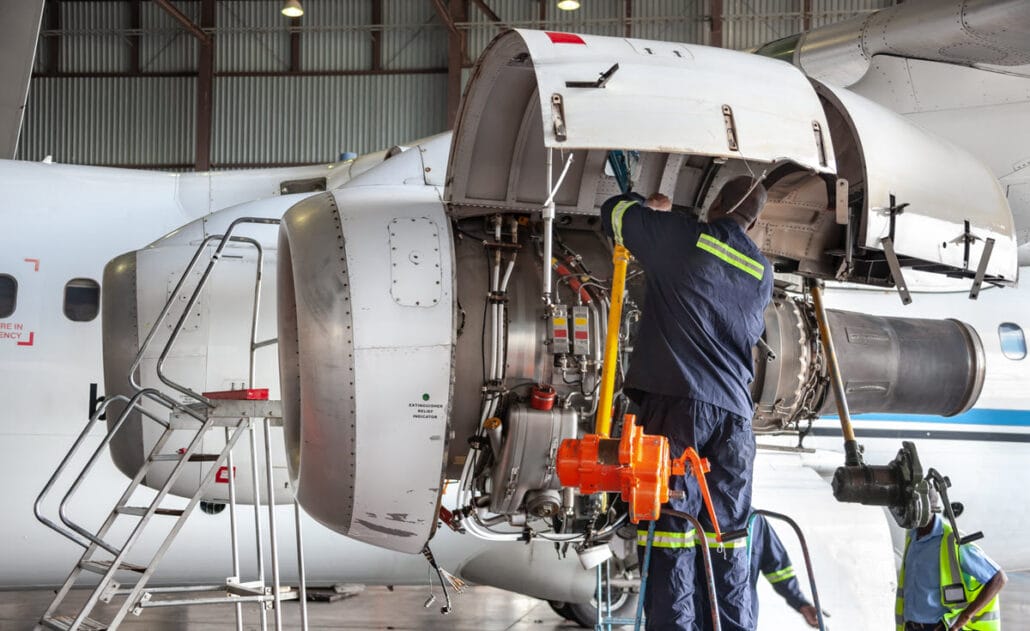 An avionics technician performing maintenance on an airplane part, a job available for 2-year degree holders.