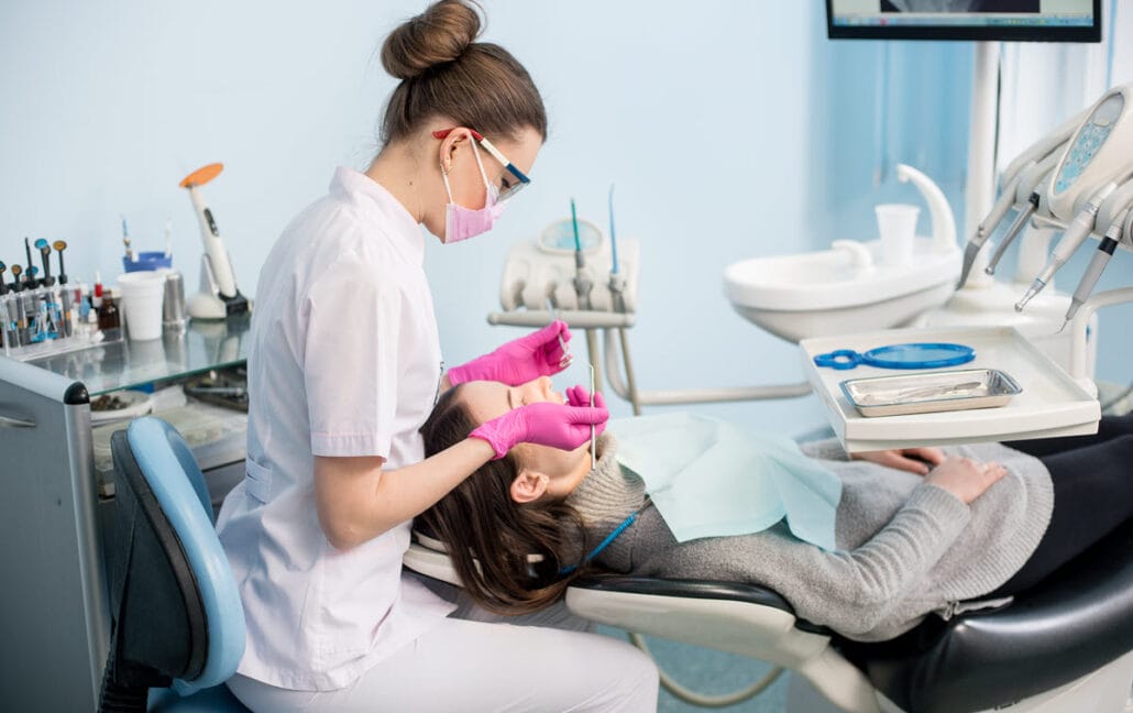 A dental hygienist cleaning a patient's teeth for optimal dental hygiene