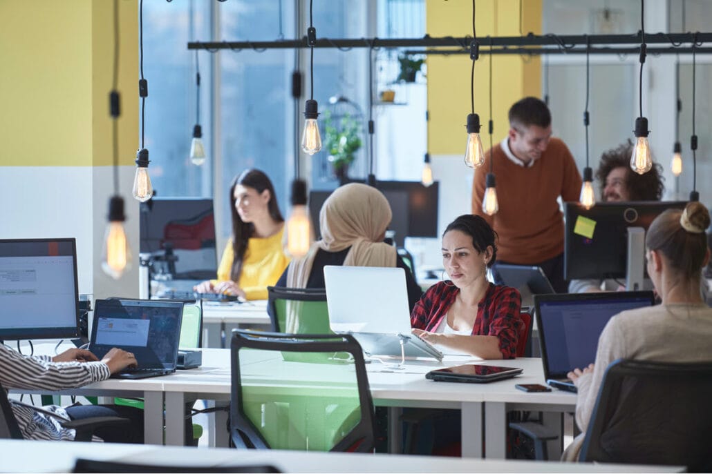 A variety of people using coworking spaces in a flexible space