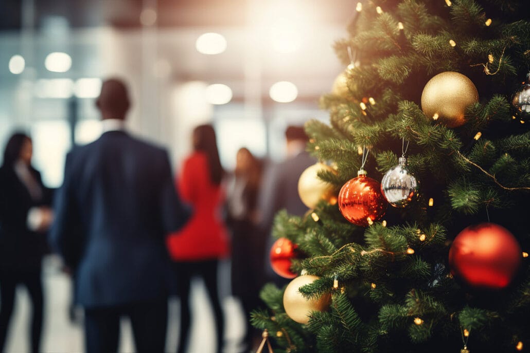 Close up of a Christmas tree with a work holiday party happening in the background