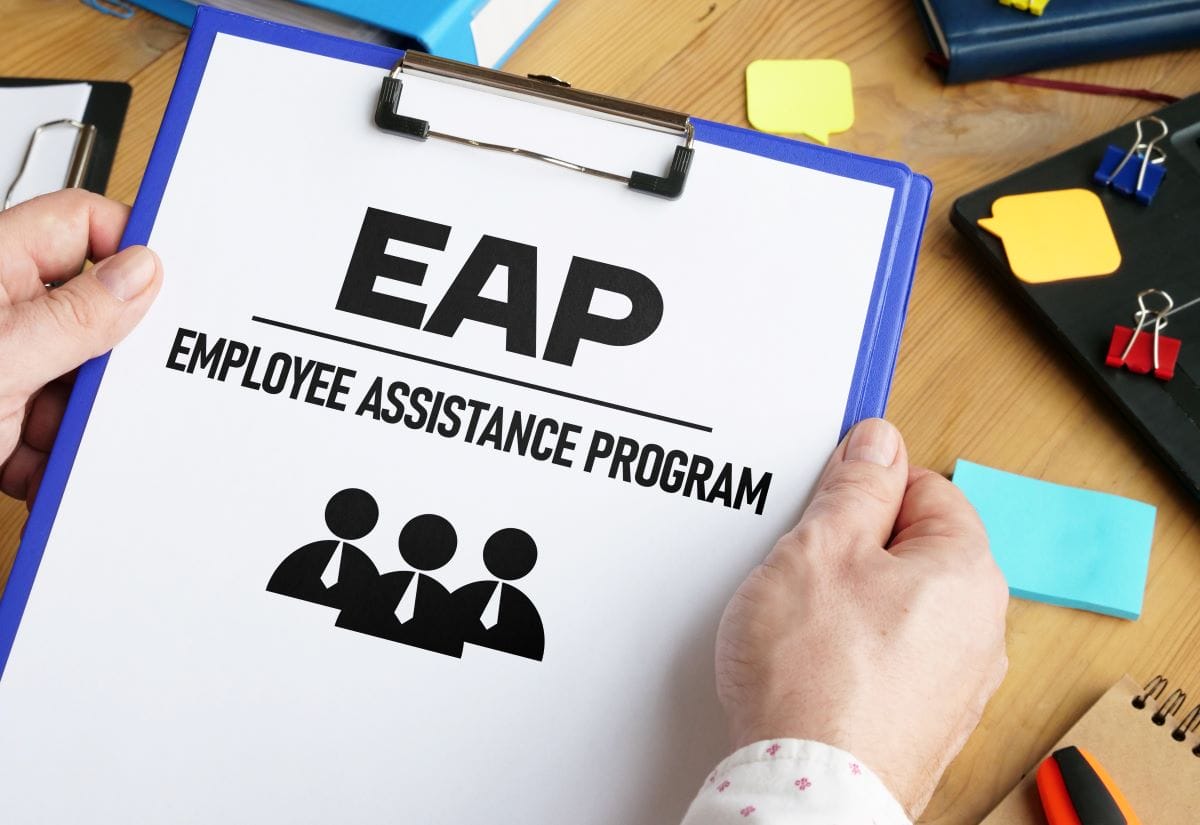 hands holding clipboard containing EAP employee assistance program paperwork