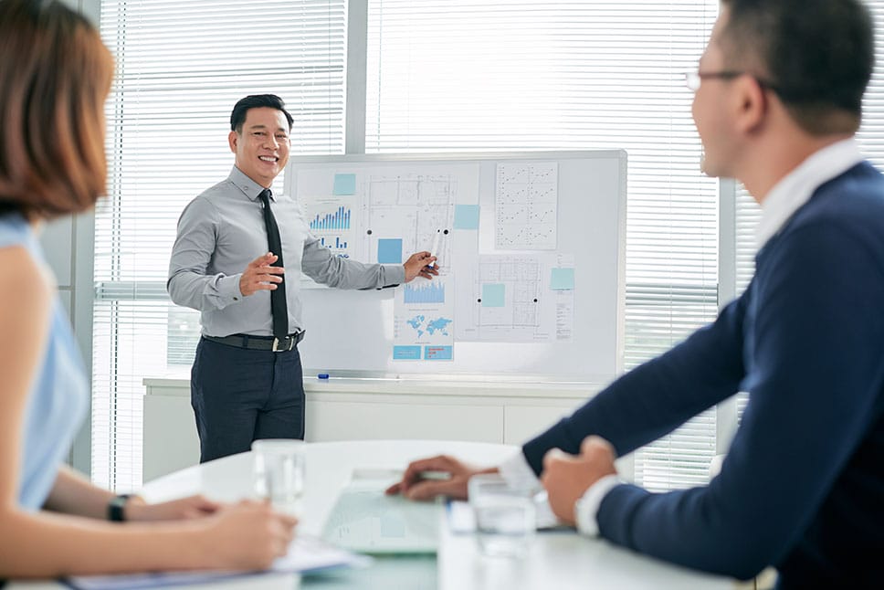 person pointing to whiteboard, conducting a meeting to promote a higher paying career