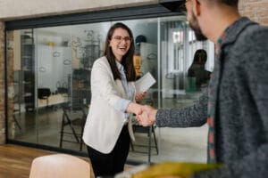 employee shaking hands with HR manager to ask for a raise